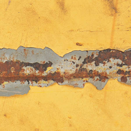 yellow enameled paint cracking and showing rusty metal