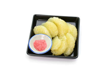 Grapefruit in a black bowl on white backgroundの写真素材