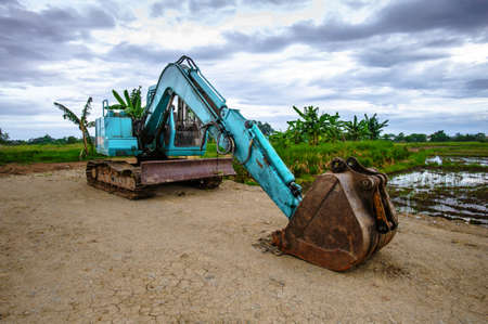 heavy excavator with shovel standing on hillの写真素材