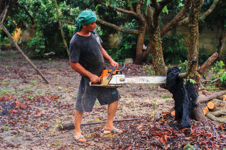 THAILAND-AUGUST,16 :Young man cutting wood to be used as firewood. THAILAND AUGUST,16 2017のeditorial素材