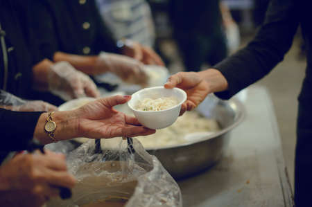 Feeding the poor to hands of a beggar. Poverty conceptの写真素材