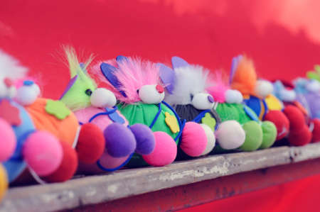 Handmade dolls placed on wooden shelvesの写真素材