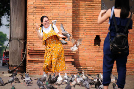 Chiangmai Thailand - March 16, 2018 : Chinese tourists are having fun with pigeons at Chiang Mai Gate.のeditorial素材