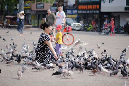 Chiangmai Thailand - March 16, 2018 : Chinese tourists are having fun with pigeons at Chiang Mai Gate.のeditorial素材