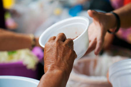 Rich people give food to the poor. starvation conceptの写真素材