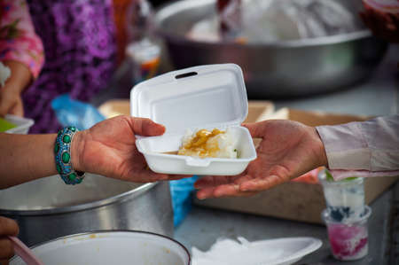 Rich people give food to the poor. starvation conceptの写真素材