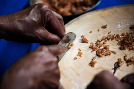 Cook is cutting dried longan as a mixtureの写真素材