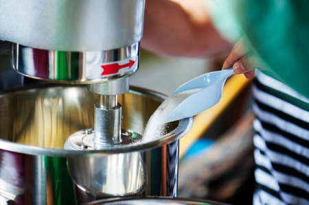 Cook is pouring sugar to make bakery.の写真素材