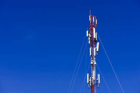 Telecommunications antenna tower in blue sky