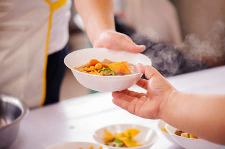 Sharing of food from volunteer hands to homeless people : The concept of feedingの写真素材