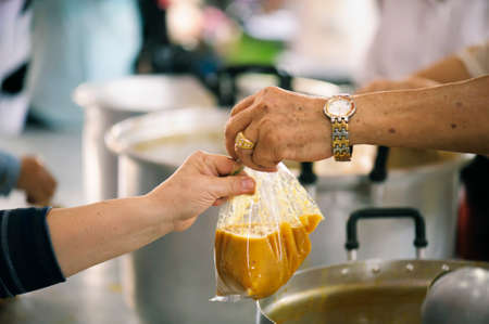 The hands of beggars offer food from the donor : The life of the poorの写真素材