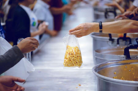 The hands of the rich give food to the hands of the poor. Concept: The concept of sharingの写真素材