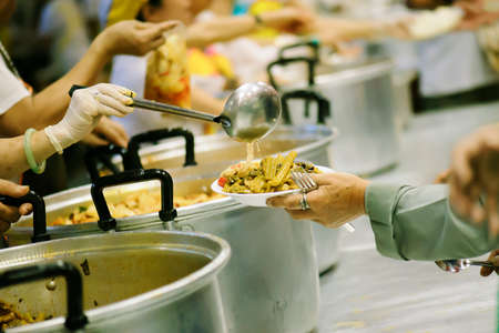 The hands of the rich give food to the hands of the poor. Concept: The concept of sharingの写真素材
