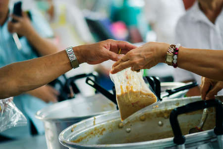 The hands of the rich give food to the hands of the poor. Concept: The concept of sharingの写真素材