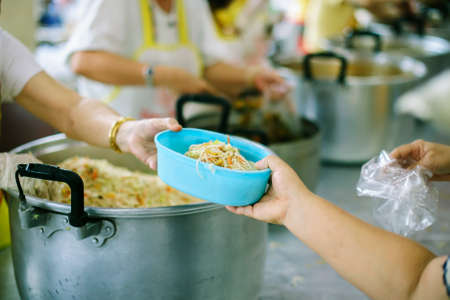 Beggar begs food from donors: concept of poverty in Asian societyの写真素材