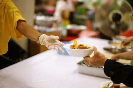 Volunteer to Feed the Hungry in Society: The Concept of Donating Food to the Poor in Societyの写真素材