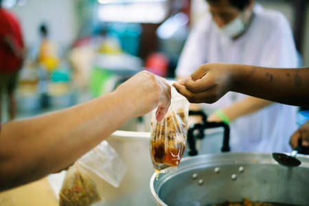 Hands of Refugees Receive Humorous Charity Food : The Concept of Food Shortageの写真素材