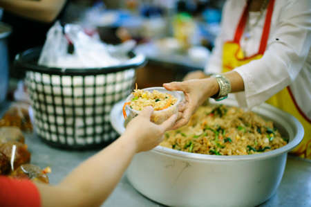 Hands of the poor are waiting for food donations to alleviate hunger : concept of feedingの写真素材
