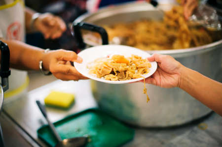 The hands of refugees have been aided by charity food to alleviate hunger : the concept of...