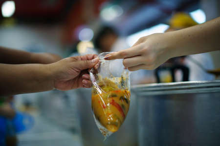 Volunteers give food to the poor : the concept of life problems, hunger in society