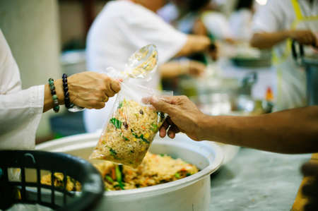 Hand begging for food from the rich's share : the concept of hopeの写真素材