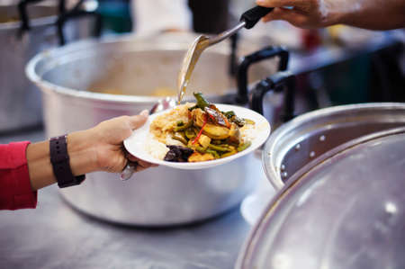 Homeless people pick up charity food from the food donors in society : concept homelessnessの写真素材