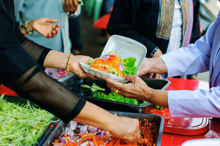 Donating food from the concern of human friends to the poor.の写真素材