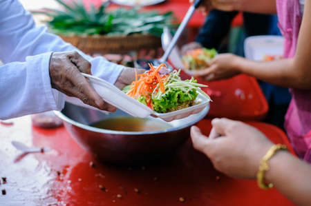 Donating food from the concern of human friends to the poor.の写真素材