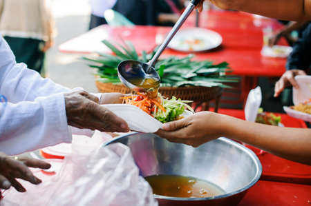 Donating food from the concern of human friends to the poor.の写真素材