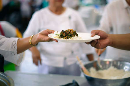 Helping the poor to enjoy eating delicious foodの写真素材