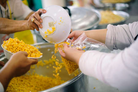 Poor people receiving food from volunteer : The concept of food donationの写真素材