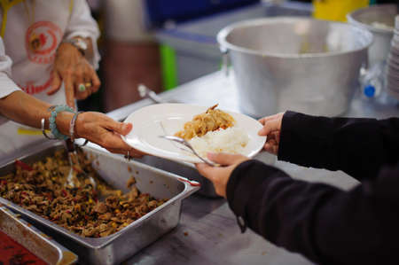 Poor people receiving food from volunteer : The concept of food donationの写真素材