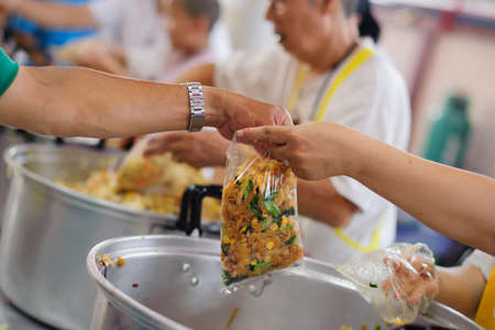 The hands of the poor waiting to receive free food: food distributionの写真素材