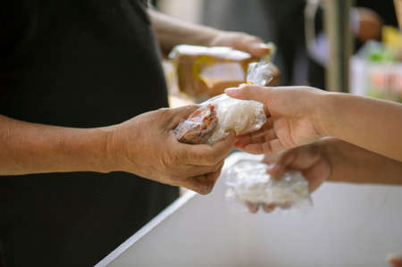 Share food from hand to hand with donations.の写真素材