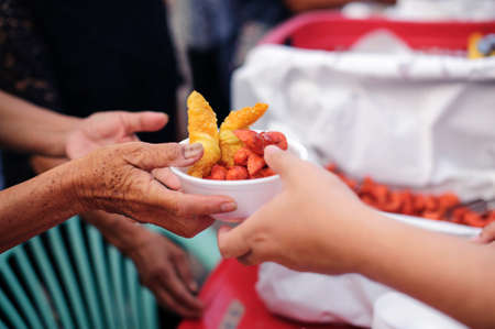Charity concept : donate food to the beggar.