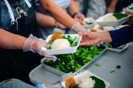 Concept of food sharing for the poor to alleviate hunger : Social Problems of Poverty Helped by Feeding : Donate food to people in society : Homeless Concepts and Povertyの写真素材