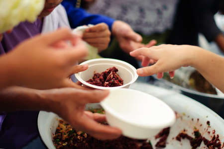 The hands of beggars offer food from the donor : The life of the poor : The concept of feedingの写真素材