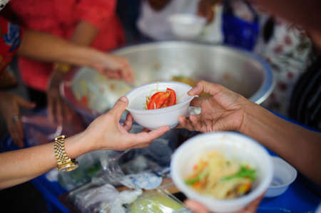 Volunteers Share Food to the Poor to Relieve Hunger : Charity concept : Donate food to hungry people : Concept of poverty and hungerの写真素材