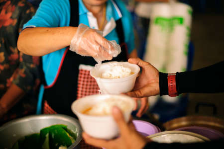 The Society of Sharing Food to Homeless and the Poorest: The Concept of Feeding : The hands of the rich give food to the hands of the poorの写真素材