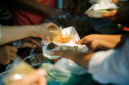 Poor people receive donated food from donors, Demonstrate mutual sharing in today's society : Beggar begs food from donorsの写真素材