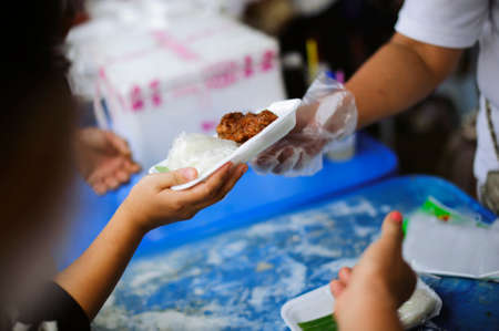 Charity food is the hope of the poor who have no money : concept of begging food : Donate food to people in society : Volunteers Share Food to the Poorの写真素材