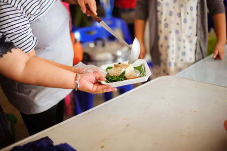 Homeless Concepts and Poverty : The hands of the poor receive food from the hands of the...