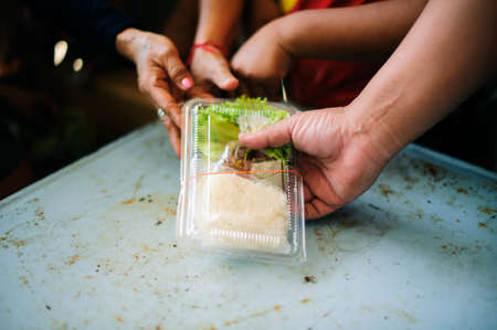Homeless Concepts and Poverty : The hands of the poor receive food from the hands of the philanthropist : concept of givingの写真素材
