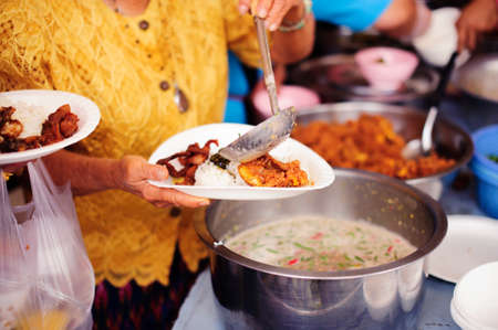 Charity food is the hope of the poor who have no money : concept of begging food : Donate food to people in society : Volunteers Share Food to the Poorの写真素材