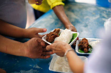 Homeless Concepts and Poverty : The hands of the poor receive food from the hands of the...