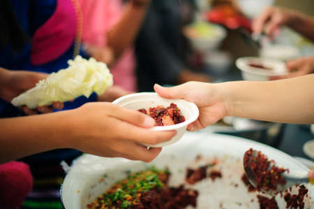 The hands of the rich give food to the hands of the poor : Social Problems of Poverty Helped by Feeding : Concepts problems of life the poor : The concept of sharingの写真素材