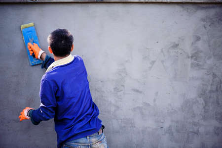The work of a plasterer by applying plaster to the wall to have a smooth surface.の写真素材