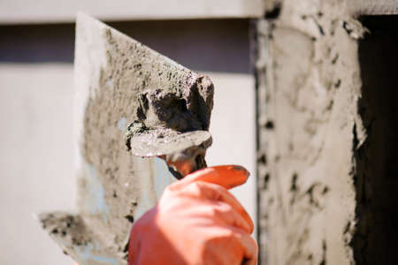 Workers are using a trowel to decorate the cement pillars into a beautiful ridge.の写真素材