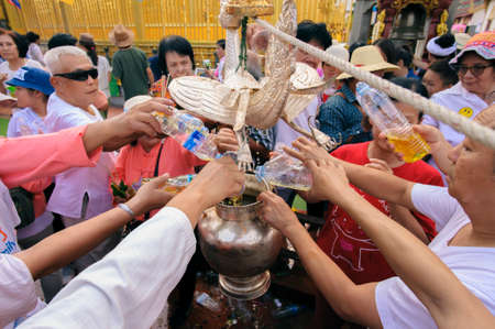 LAMPHUN, THAILAND - MAY 18, 2019 : People together pour water together to bathe Phra That Chedi Hariphunchai in Lamphun, Thailand.のeditorial素材
