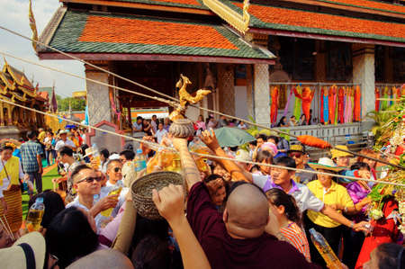 LAMPHUN, THAILAND - MAY 18, 2019 : People together pour water together to bathe Phra That Chedi Hariphunchai in Lamphun, Thailand.のeditorial素材